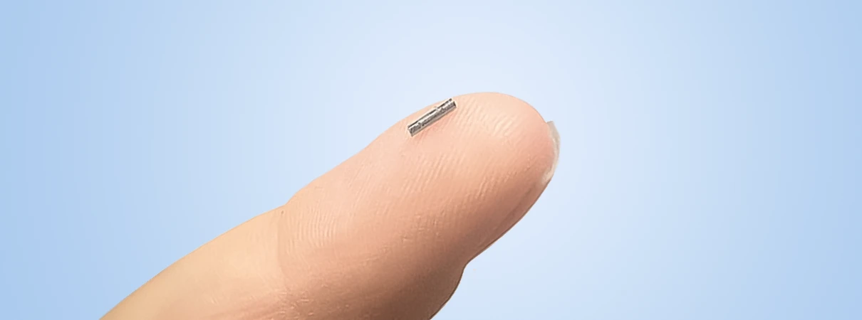 Ein sogenannter Seed von 5mm Länge auf einem Finger. Diese Seeds werden bei der Brachytherapie in die Prostata eingesetzt.